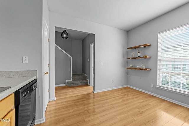 interior space with black dishwasher and light hardwood / wood-style flooring