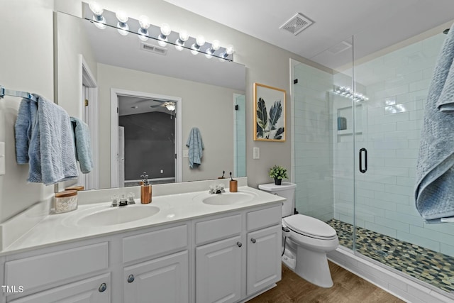 bathroom with vanity, toilet, an enclosed shower, and hardwood / wood-style floors