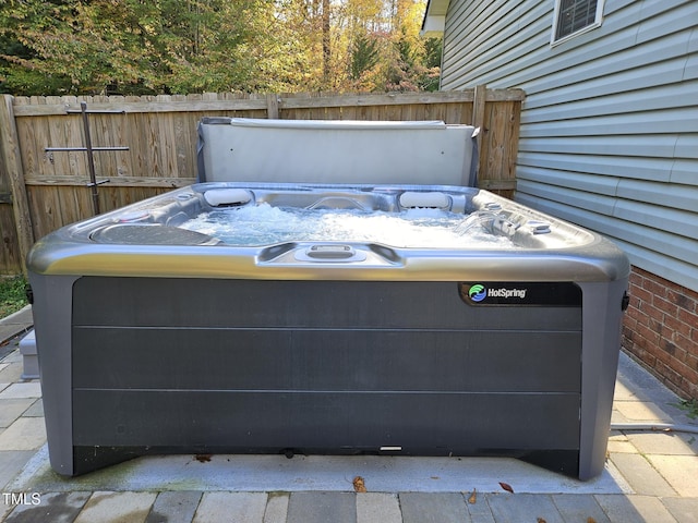 exterior details with brick siding, fence, and a hot tub