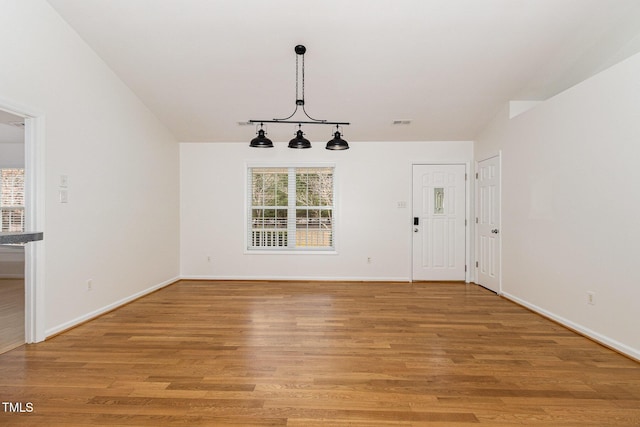 unfurnished dining area with light wood-type flooring, plenty of natural light, visible vents, and baseboards