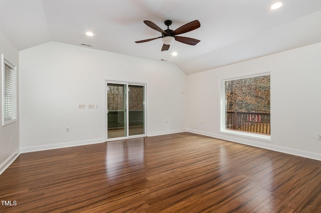 spare room with a wealth of natural light, lofted ceiling, and dark wood finished floors