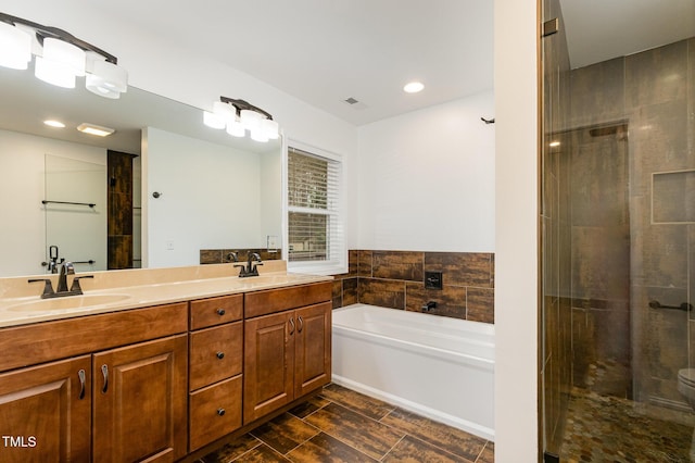 bathroom with double vanity, visible vents, a sink, a shower stall, and a bath