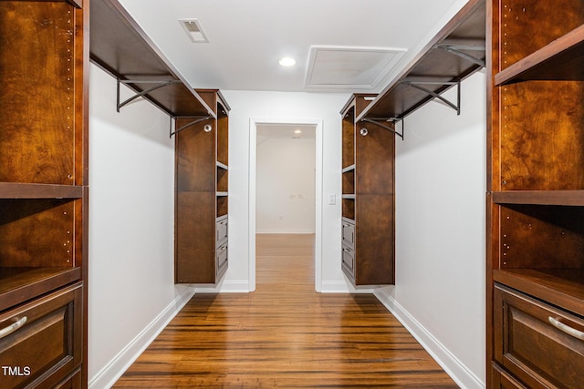 spacious closet featuring dark wood-style floors, attic access, and visible vents