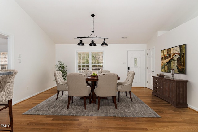 dining space featuring dark wood-style flooring, plenty of natural light, visible vents, and baseboards