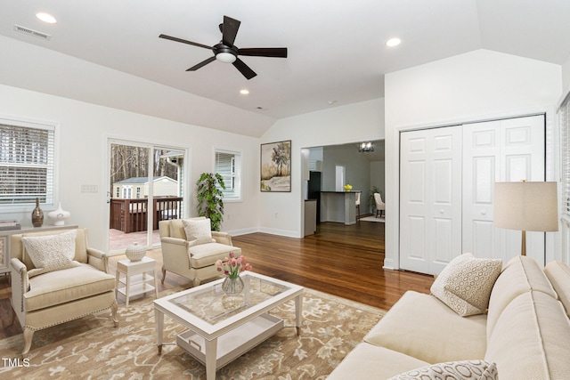 living room featuring lofted ceiling, visible vents, recessed lighting, and wood finished floors