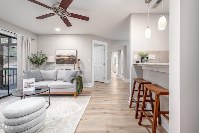 living room with ceiling fan and light hardwood / wood-style flooring