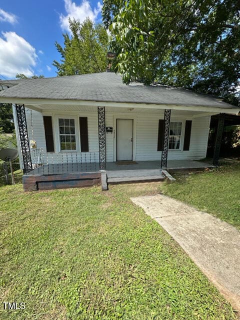 view of front of house with a front yard and covered porch