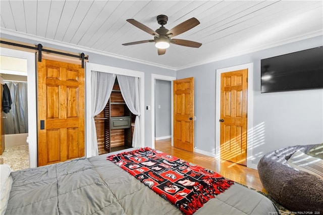 bedroom featuring ornamental molding, a barn door, wood ceiling, and ceiling fan