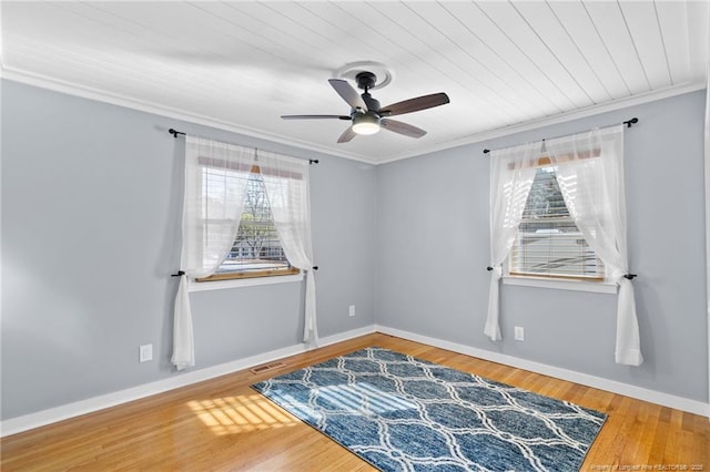 empty room featuring hardwood / wood-style flooring, ornamental molding, and ceiling fan