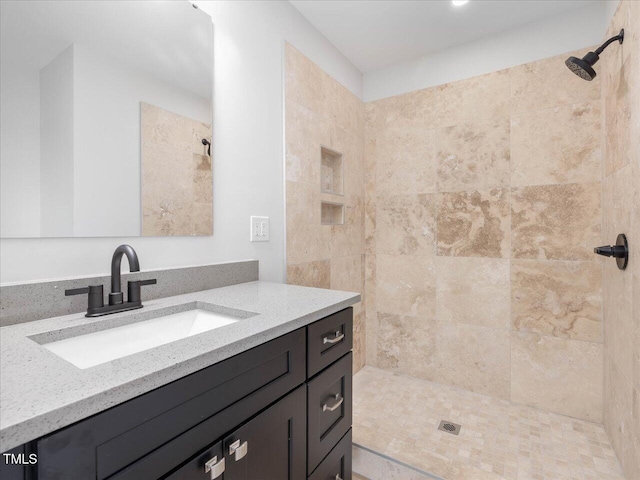 bathroom with vanity and tiled shower