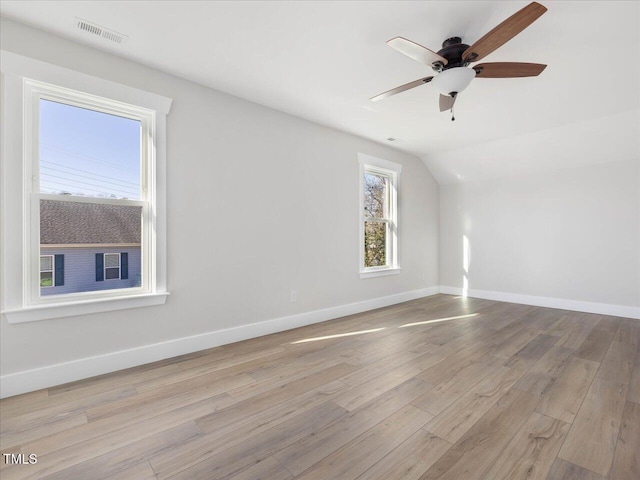 spare room with light hardwood / wood-style flooring, vaulted ceiling, and ceiling fan