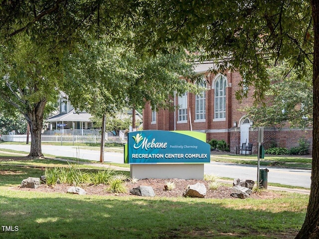 community sign featuring a lawn