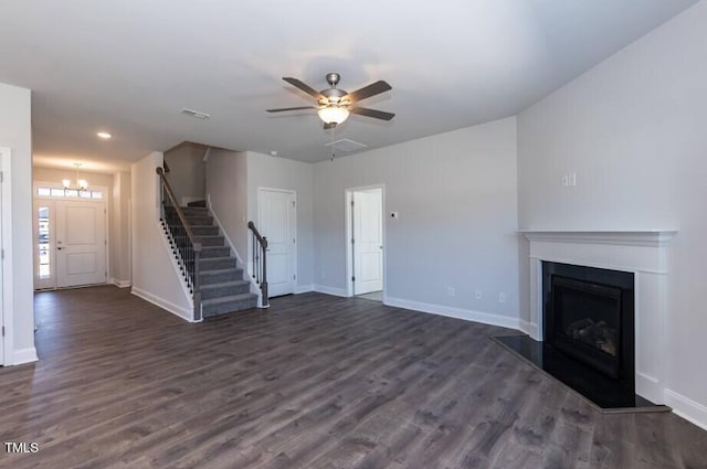 unfurnished living room featuring dark wood-type flooring and ceiling fan with notable chandelier