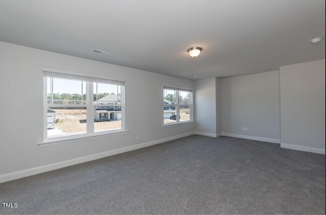 unfurnished room with dark carpet