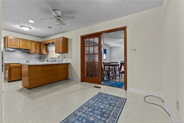 kitchen featuring french doors, ceiling fan, decorative backsplash, and a textured ceiling