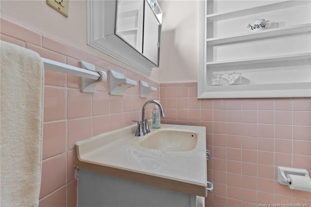 bathroom featuring vanity and tile walls