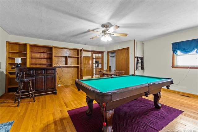 game room with ceiling fan, pool table, light hardwood / wood-style floors, and a textured ceiling