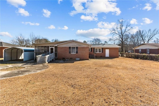 view of front of property featuring a carport, a sunroom, and a front yard