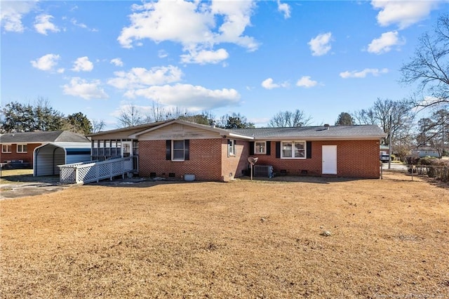 ranch-style home with central AC unit, a front yard, and a carport