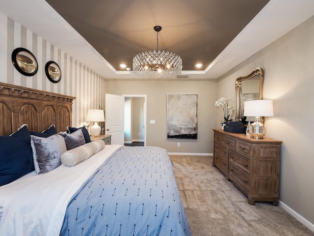 carpeted bedroom with a raised ceiling and a chandelier