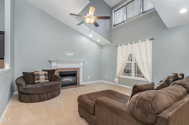 living room with light carpet, high vaulted ceiling, a tile fireplace, and ceiling fan