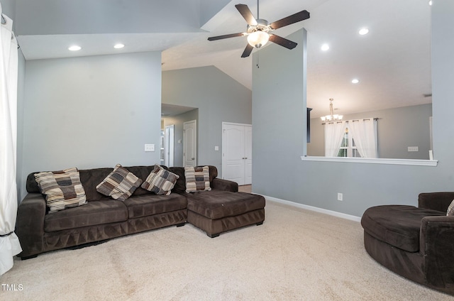 carpeted living room with ceiling fan with notable chandelier and high vaulted ceiling