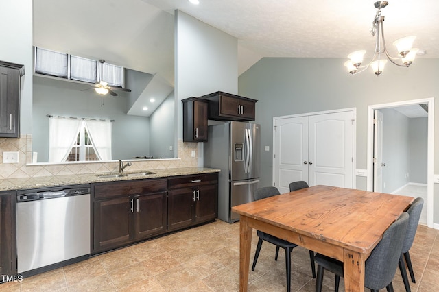 kitchen featuring dark brown cabinetry, sink, light stone counters, appliances with stainless steel finishes, and decorative backsplash