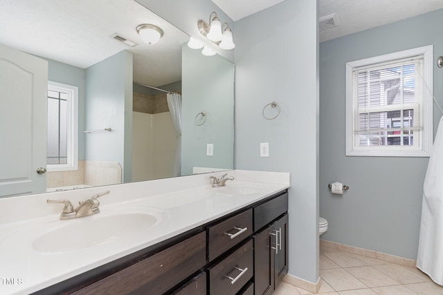 bathroom featuring tile patterned flooring, vanity, walk in shower, toilet, and a textured ceiling