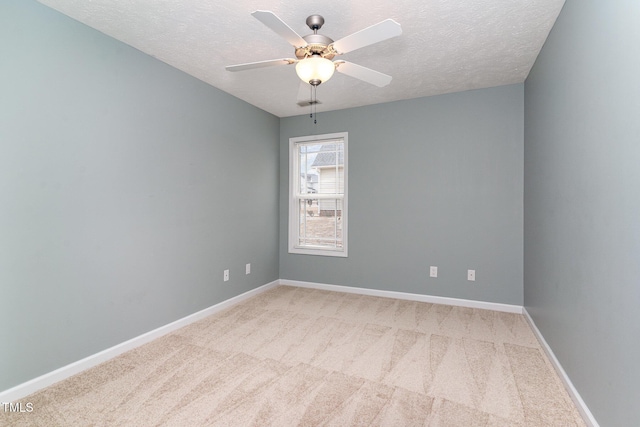 spare room with ceiling fan, light carpet, and a textured ceiling