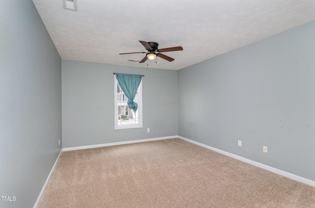 spare room featuring ceiling fan, carpet flooring, and a textured ceiling