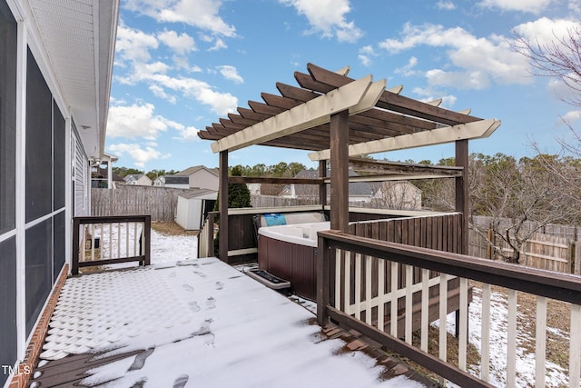 snow covered deck featuring a hot tub and a pergola