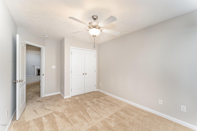 2228 Lakedale Dr, Fayetteville, NC 28306 - unfurnished bedroom with light colored carpet, a closet, baseboards, ceiling fan, and a textured ceiling