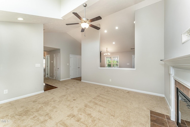2228 Lakedale Dr, Fayetteville, NC 28306 - unfurnished living room featuring a ceiling fan, a tiled fireplace, carpet flooring, high vaulted ceiling, and baseboards