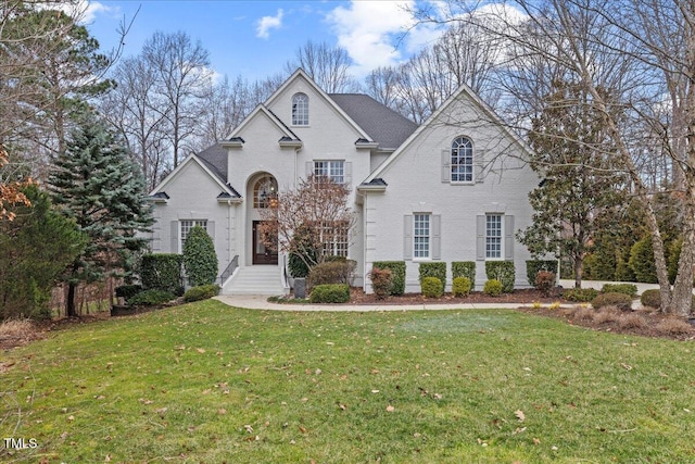 view of front of home with brick siding and a front yard