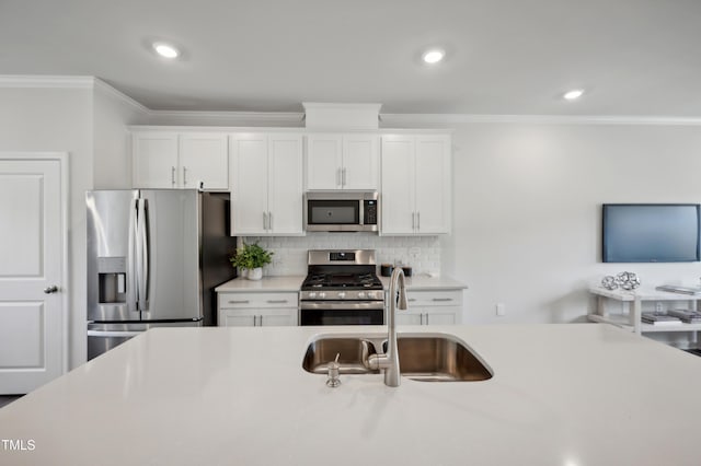 kitchen with sink, crown molding, backsplash, stainless steel appliances, and white cabinets