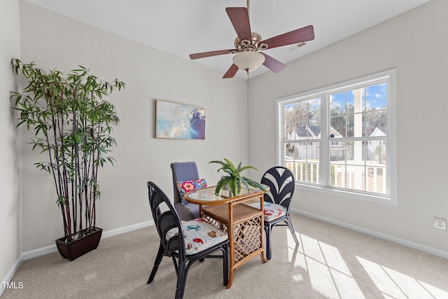 carpeted dining room with ceiling fan