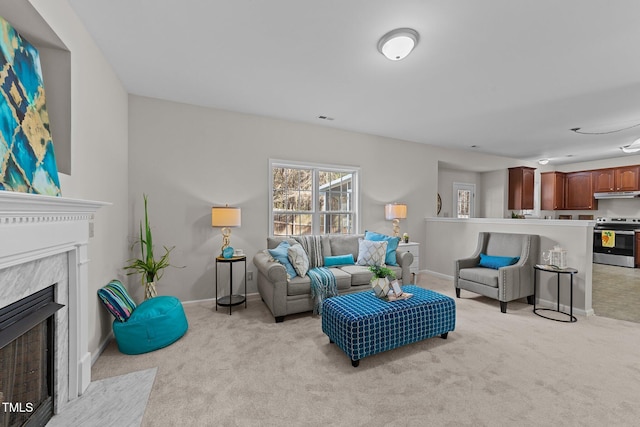 living room with light colored carpet and a high end fireplace