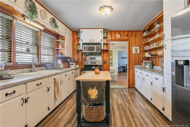 kitchen featuring sink, appliances with stainless steel finishes, white cabinetry, a center island, and light hardwood / wood-style floors