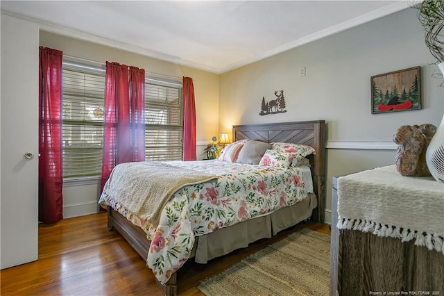 bedroom with ornamental molding and dark hardwood / wood-style flooring