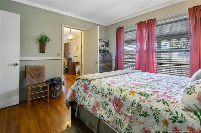 bedroom with crown molding and wood-type flooring