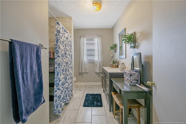 bathroom featuring tile patterned flooring, a textured ceiling, and toilet