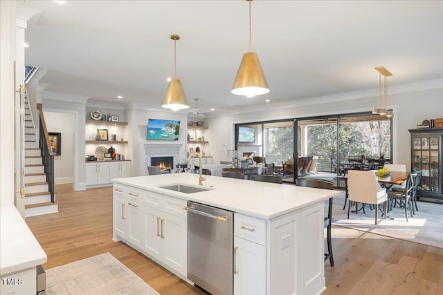 kitchen with sink, decorative light fixtures, dishwasher, a kitchen island with sink, and white cabinets