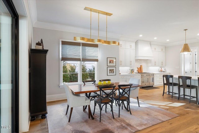 dining room featuring ornamental molding and light hardwood / wood-style floors