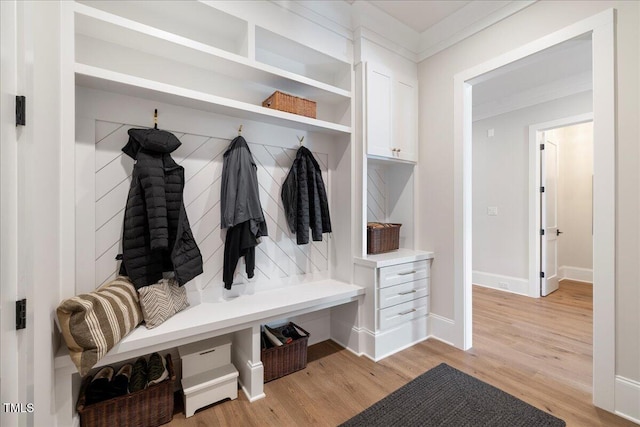 mudroom with ornamental molding and light hardwood / wood-style floors