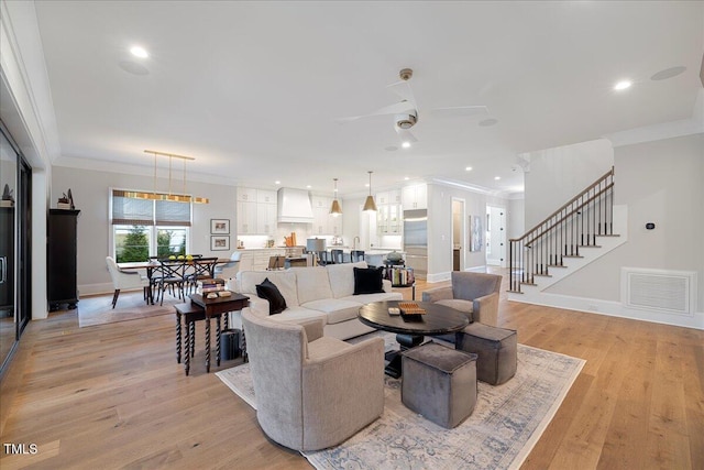 living room featuring crown molding, ceiling fan, and light wood-type flooring