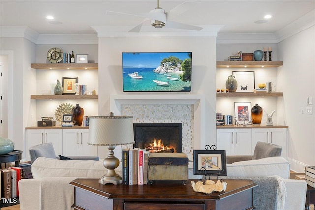 living room featuring built in shelves, ceiling fan, and crown molding