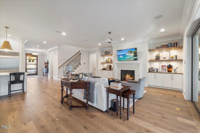 living room with ornamental molding and light hardwood / wood-style floors