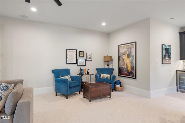 sitting room with ceiling fan and light colored carpet