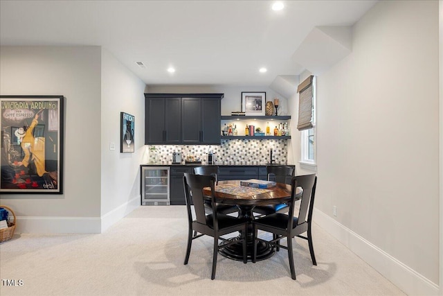 carpeted dining space featuring beverage cooler and indoor bar