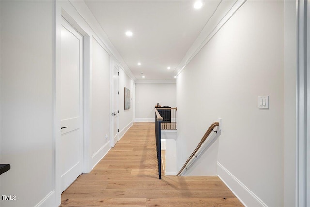 hall with ornamental molding and light wood-type flooring